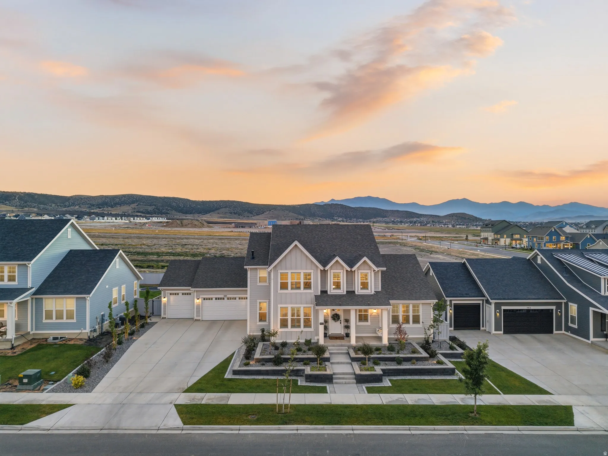Contemporary residence featuring light gray siding with white trim, a dark gray shingle roof, and a covered front porch