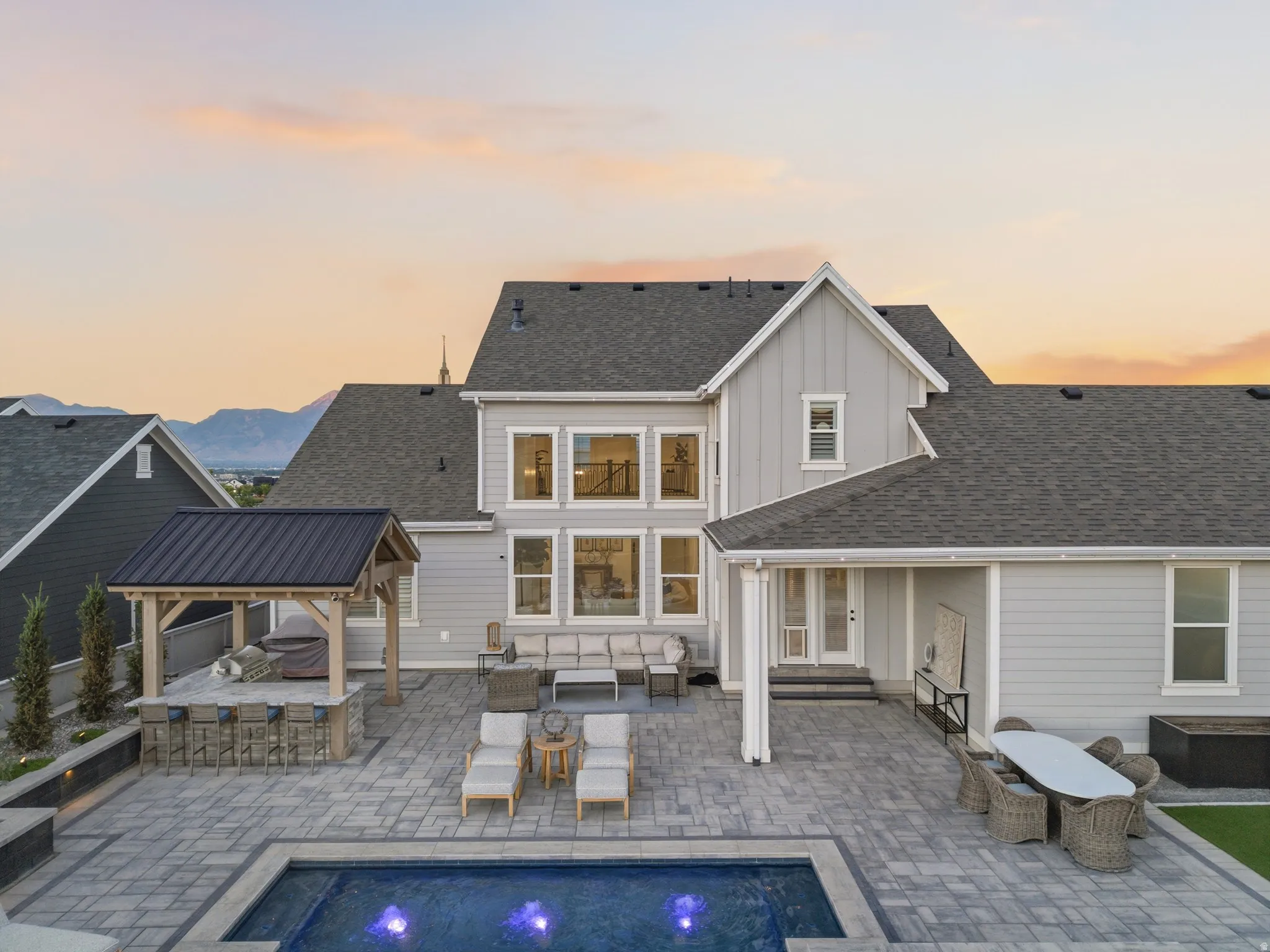 Expansive paver patio featuring a built-in outdoor kitchen with a metal roof pavilion