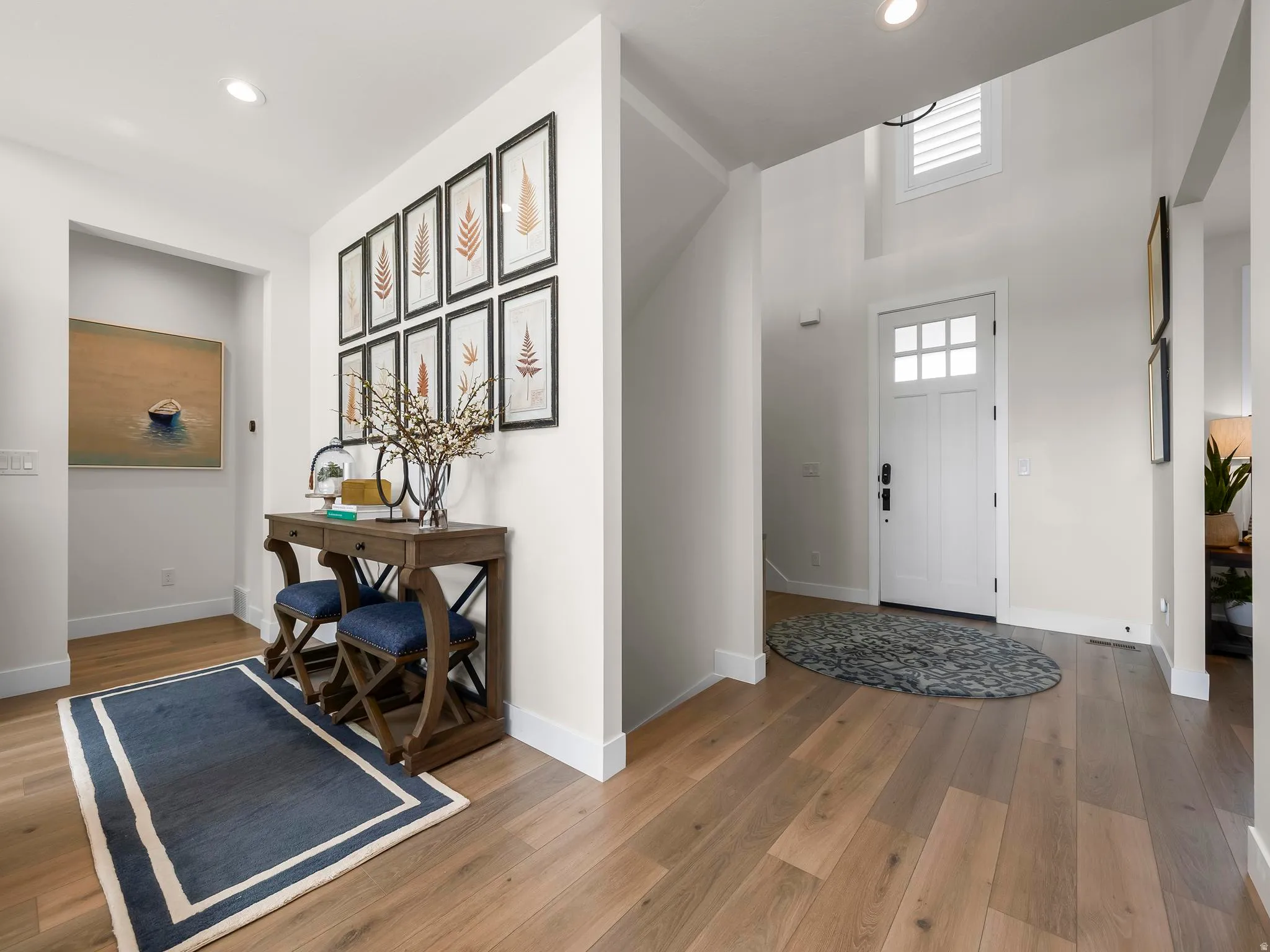 Two-story foyer with transom window, wood-finish flooring, recessed lighting, and white baseboards