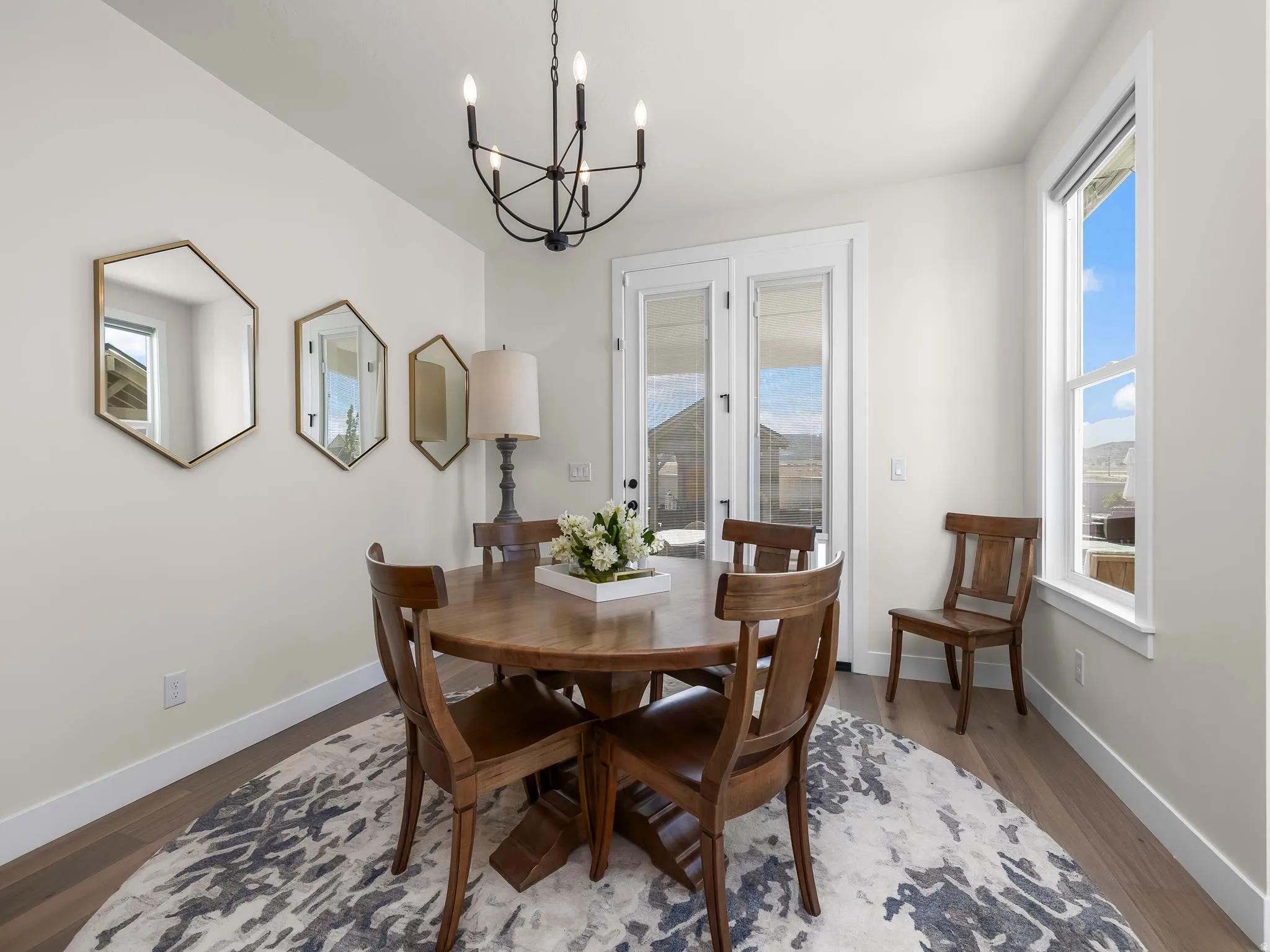 Dining area featuring wood-finish flooring and a contemporary black chandelier