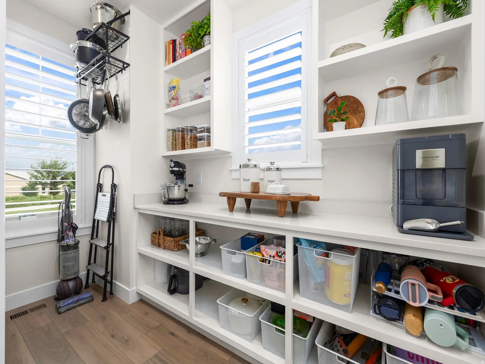 Custom built-in pantry with extensive shelving, white countertops, and wood-finish flooring
