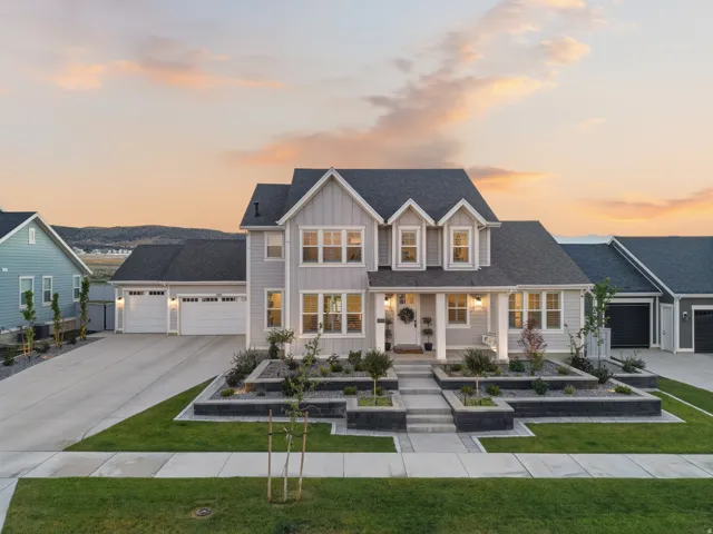 Contemporary exterior with light gray siding, dark shingle roof, and multiple dormer windows
