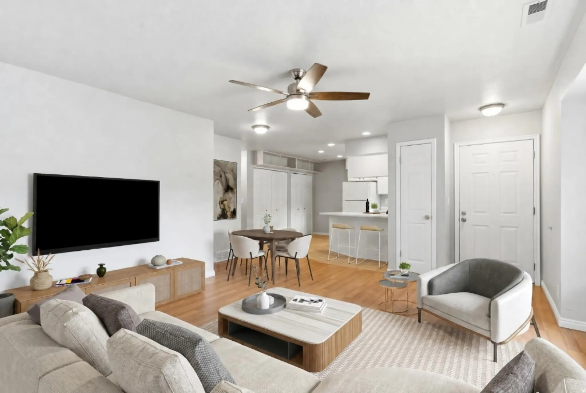 Open-concept living area featuring wood-finish flooring and a ceiling fan with integrated lighting