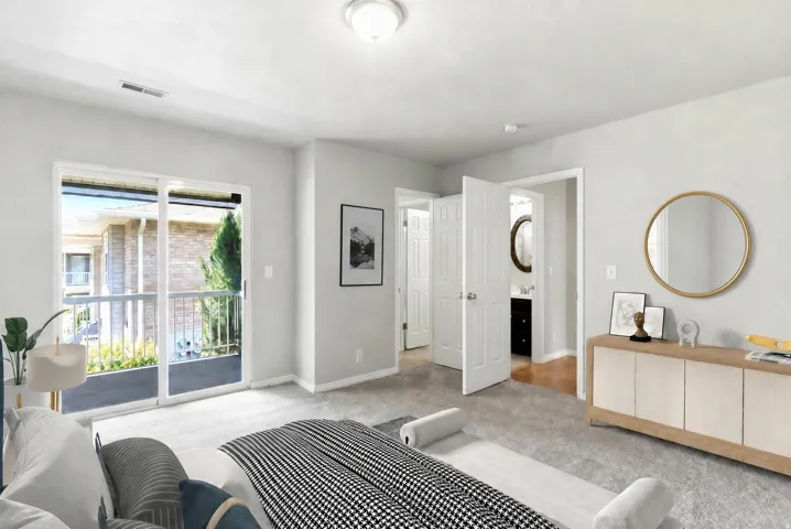 Bedroom featuring a sliding glass door leading to a balcony, light gray wall paint, and gray carpet flooring