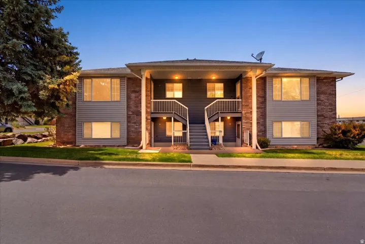Two-story building exterior featuring horizontal siding and brick accents