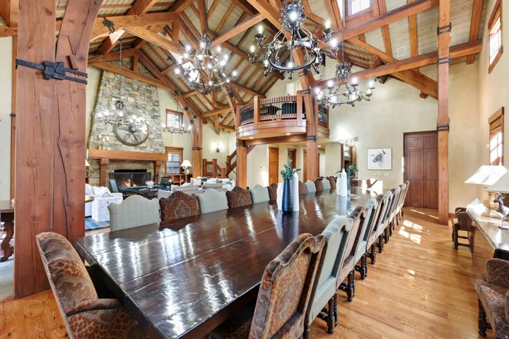 Spacious dining area featuring a large, polished wood table and hardwood flooring