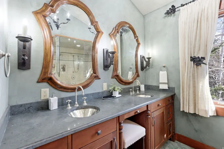 Dual vanity with wood-finish cabinetry and integrated seating area