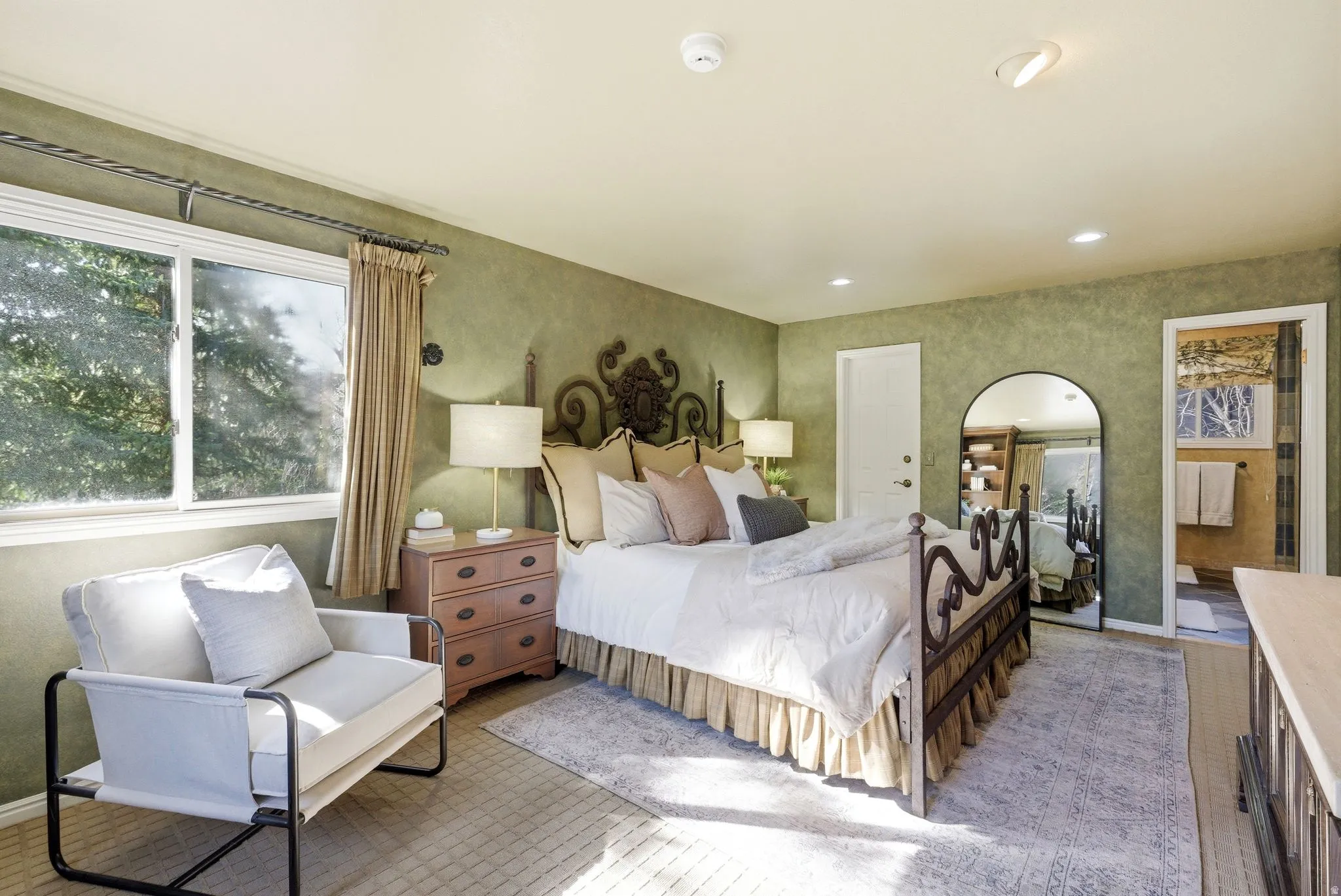 Spacious room featuring textured green walls, recessed lighting, and a large window