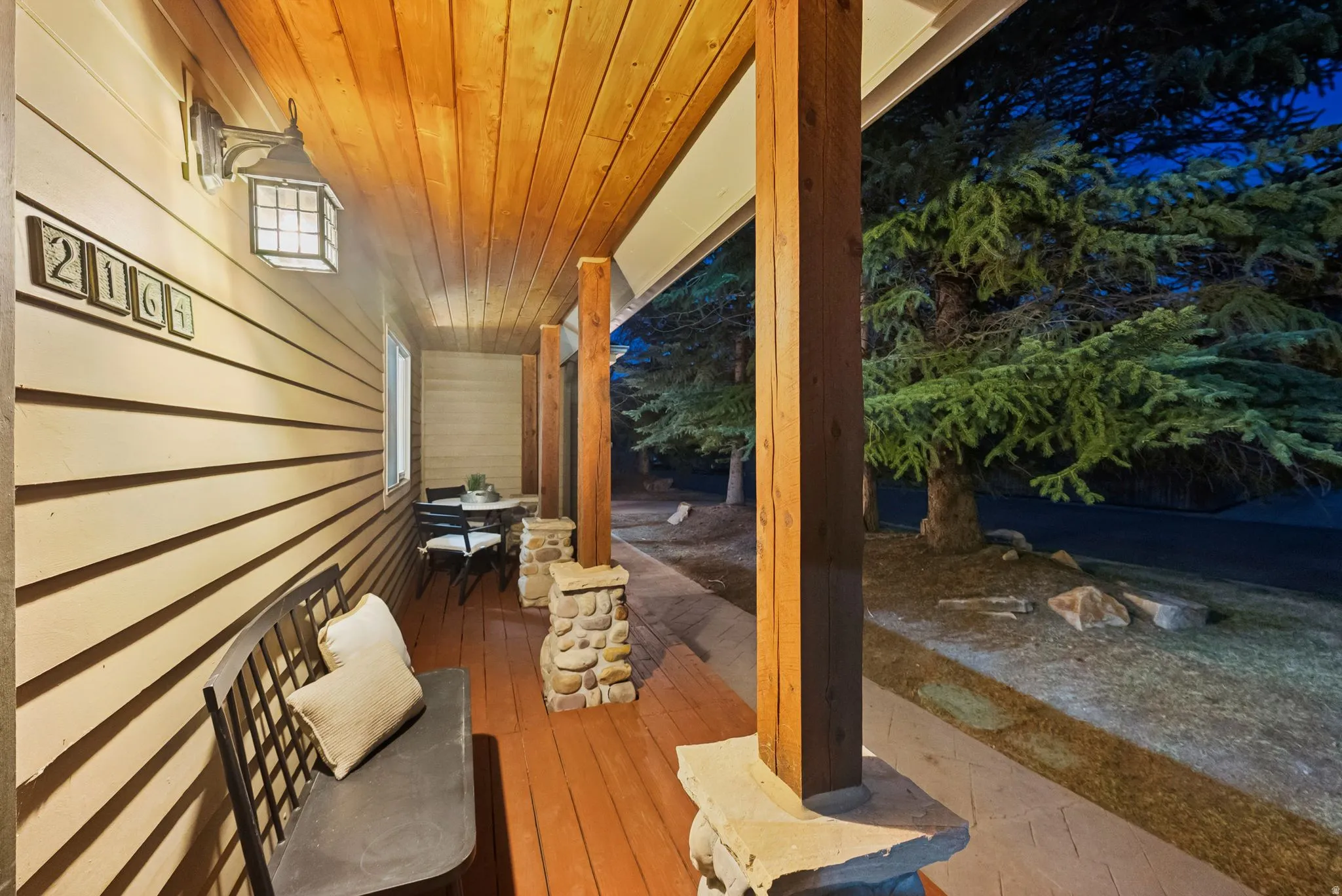 Front porch featuring a wood-finish ceiling, wood-finish flooring, and stone accents