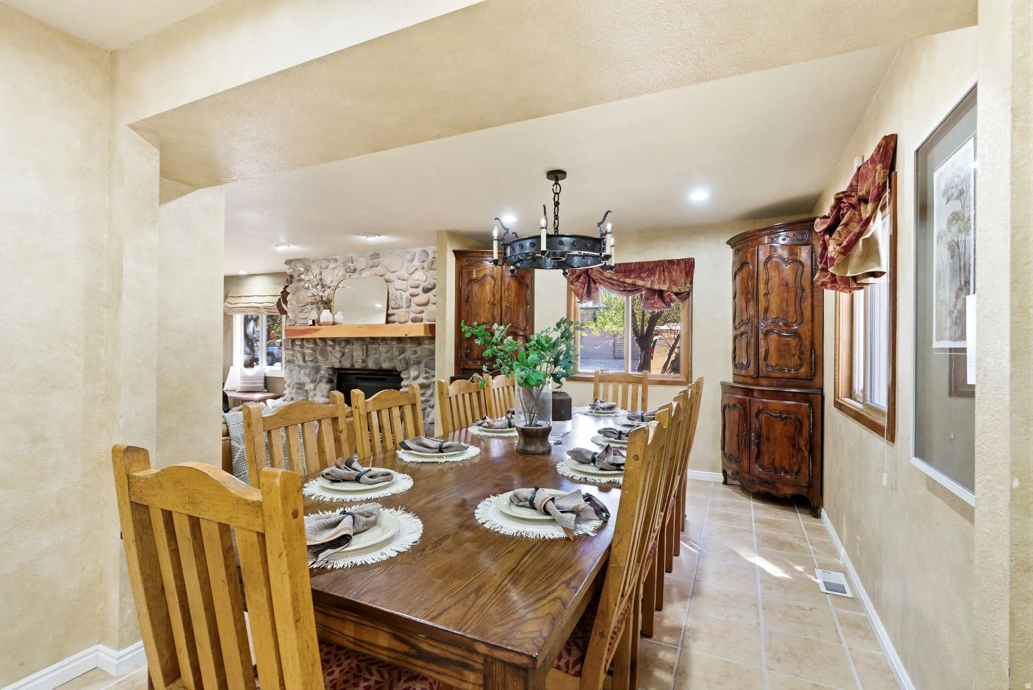 Dining room featuring a wood-finish dining table and chairs, tile flooring, and a wrought iron chandelier