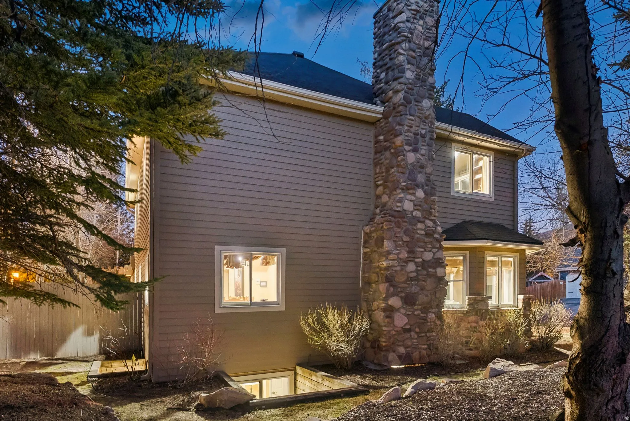 Stone-clad chimney and bay window with siding exterior