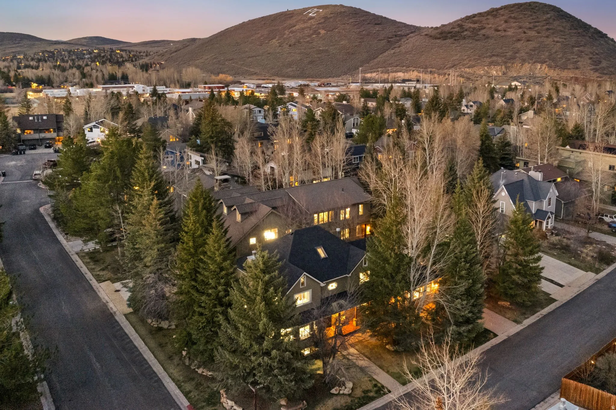 Aerial perspective of a neighborhood featuring residential properties and mature trees