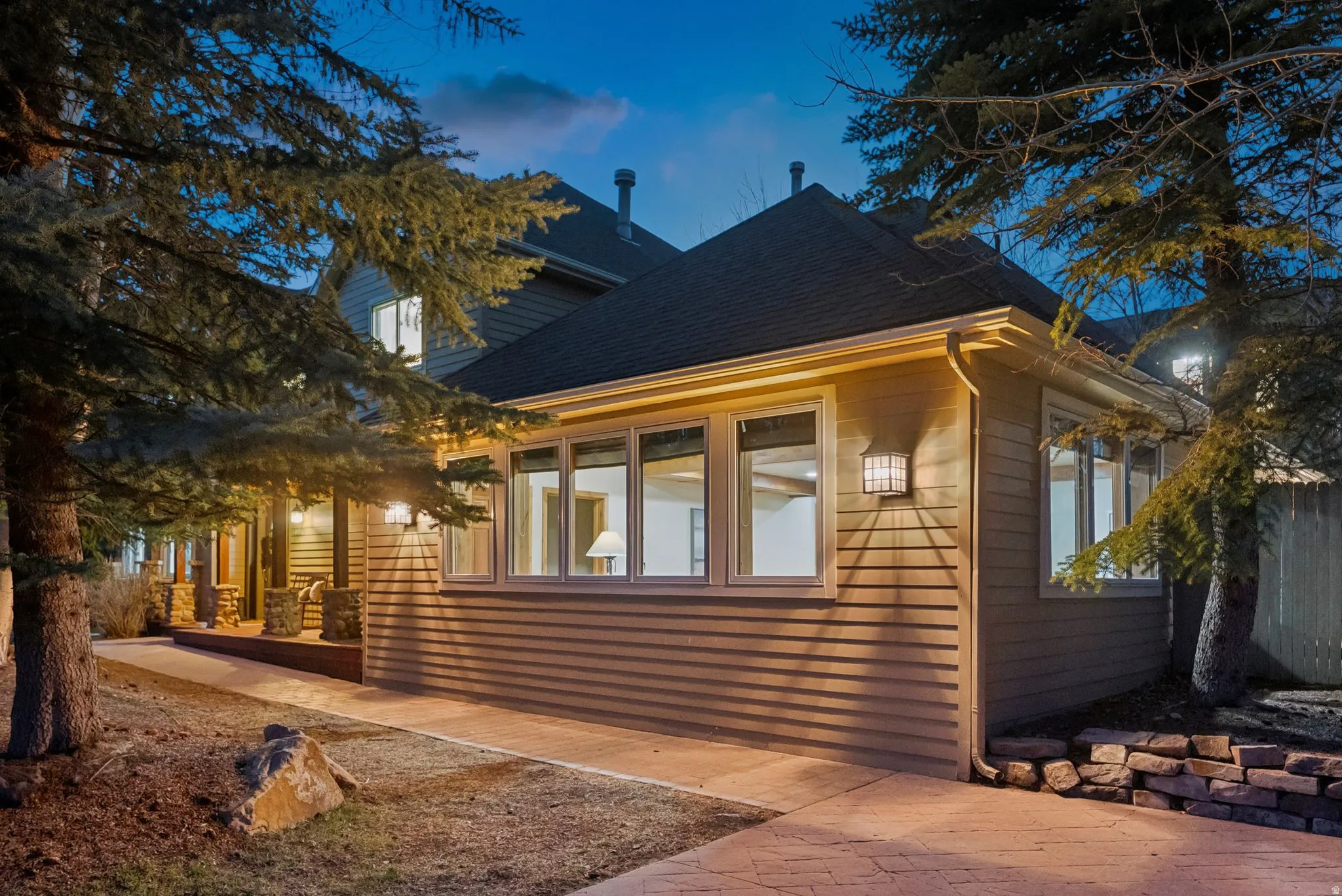 Exterior featuring horizontal siding, multiple windows, and a dark shingle roof