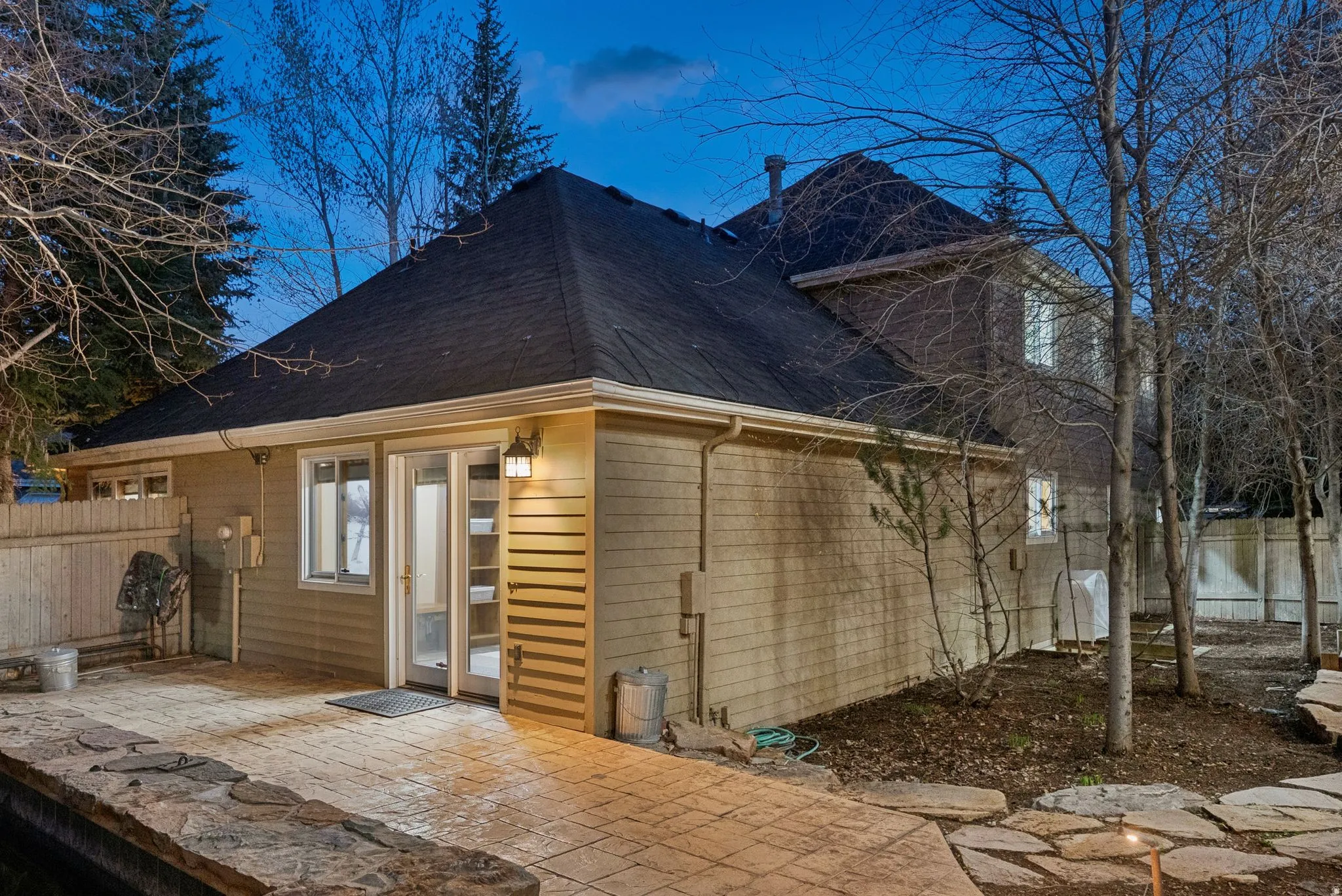 Exterior featuring a stamped concrete patio, stone retaining wall, and natural stone stepping pavers
