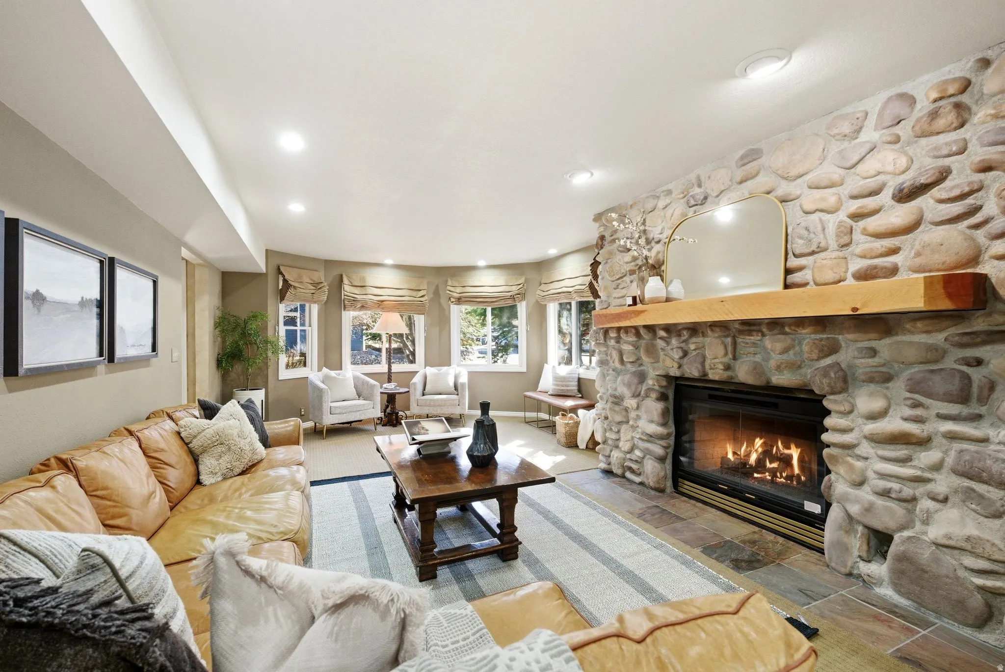 Stone-clad fireplace with a natural wood mantel