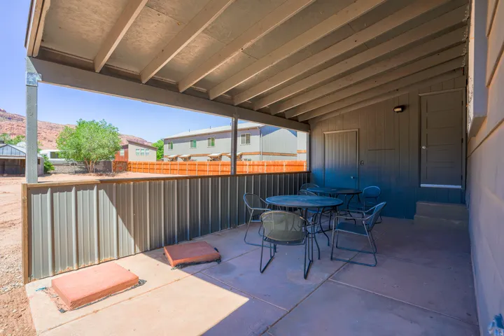 Covered patio with a concrete surface, featuring an exposed beam ceiling structure