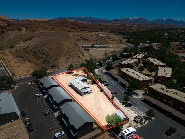 Expansive lot outlined in red, featuring a single-story structure with a metal roof