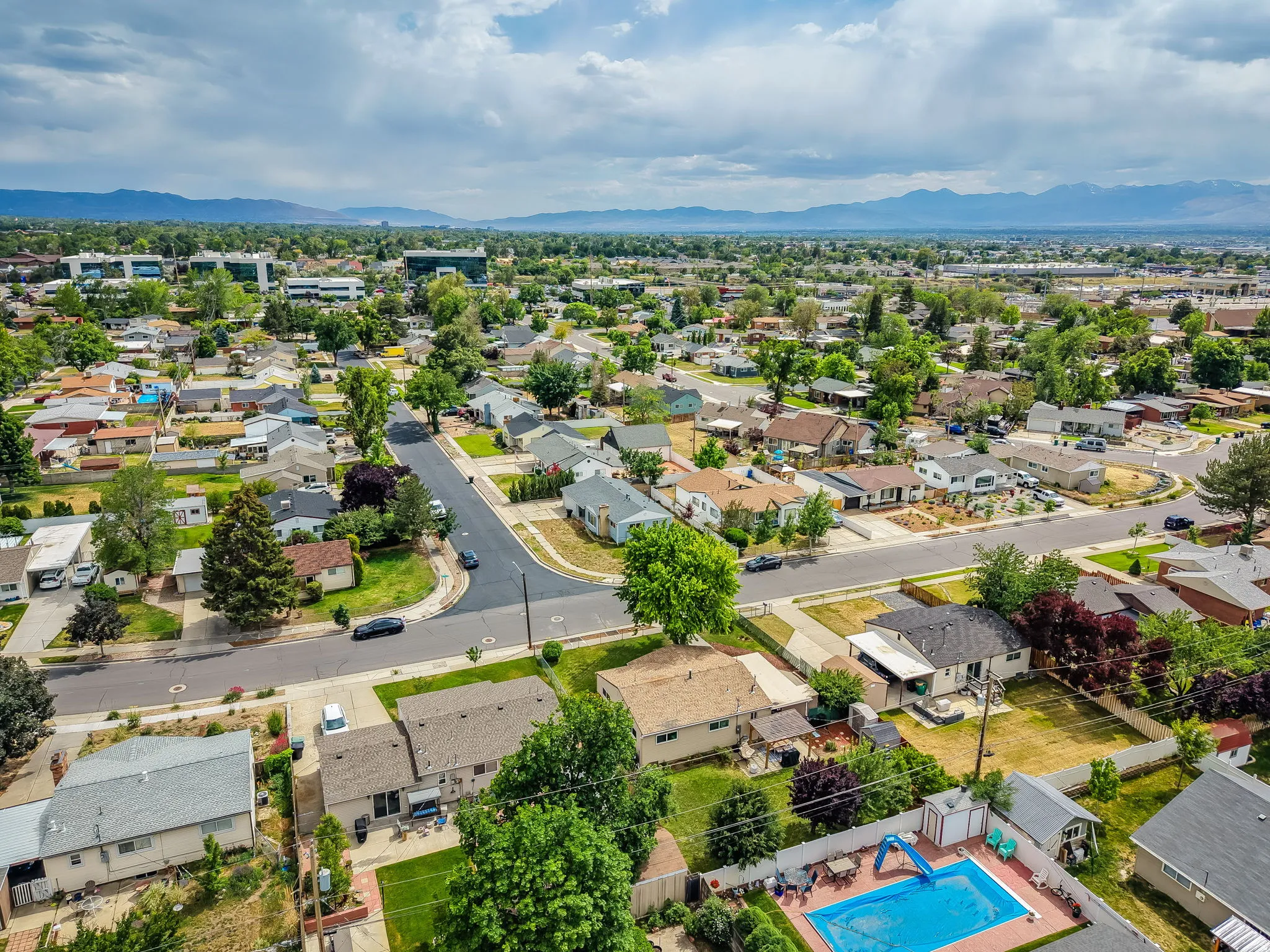 Expansive neighborhood showcasing a variety of residential properties, mature trees, and paved streets