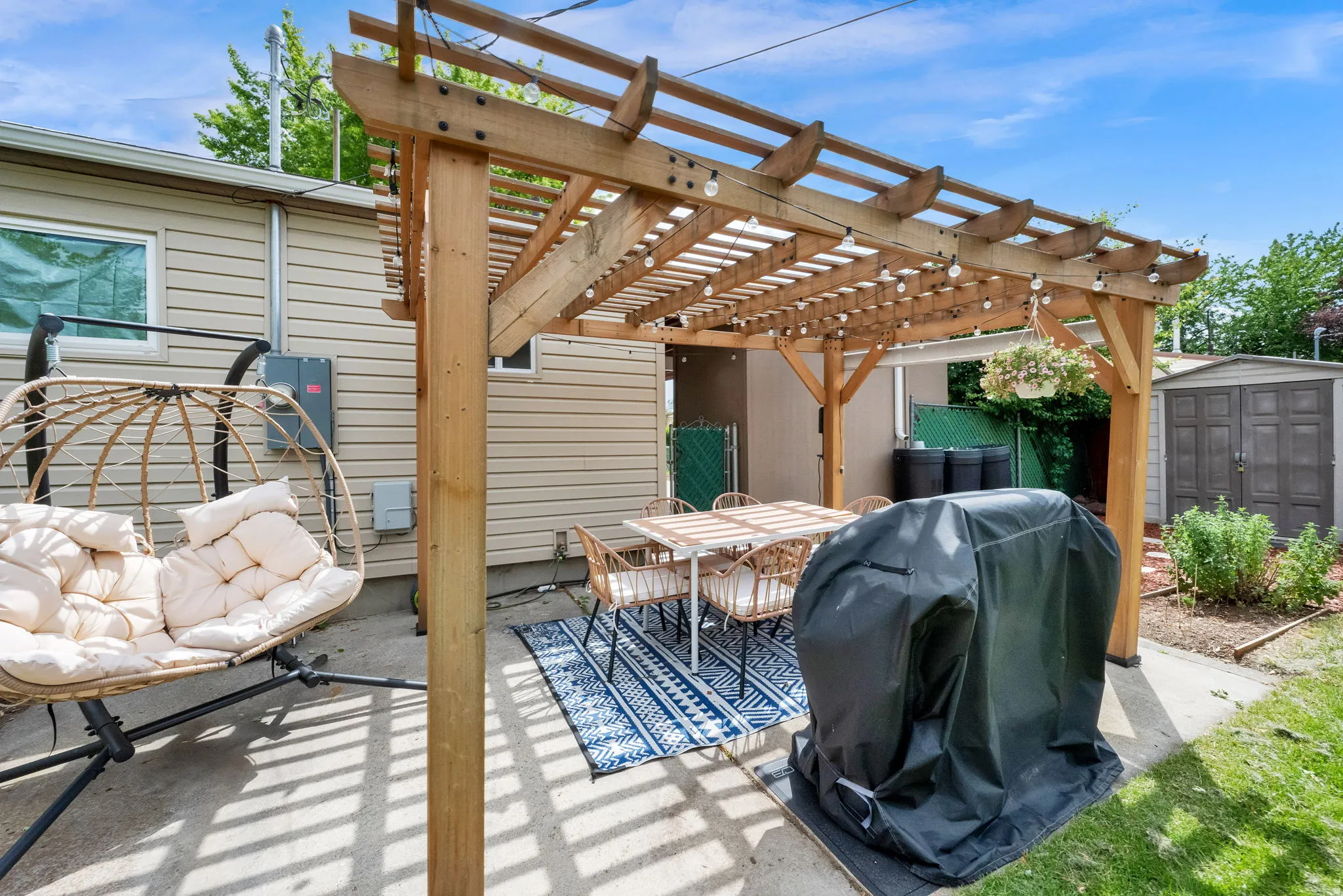 Wood pergola with string lighting over a concrete patio
