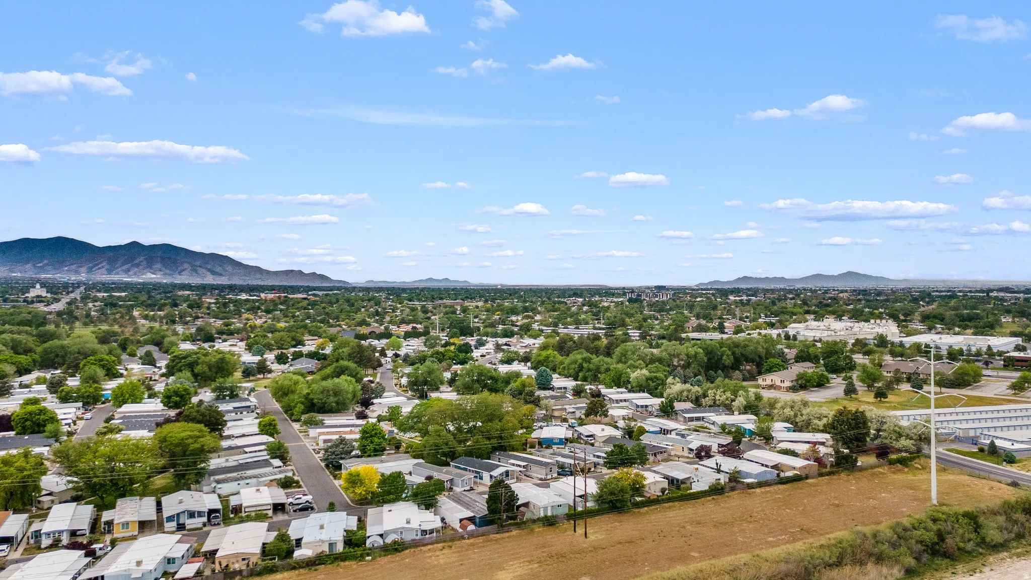 Expansive aerial perspective showcasing a residential area with a prominent mountain range backdrop