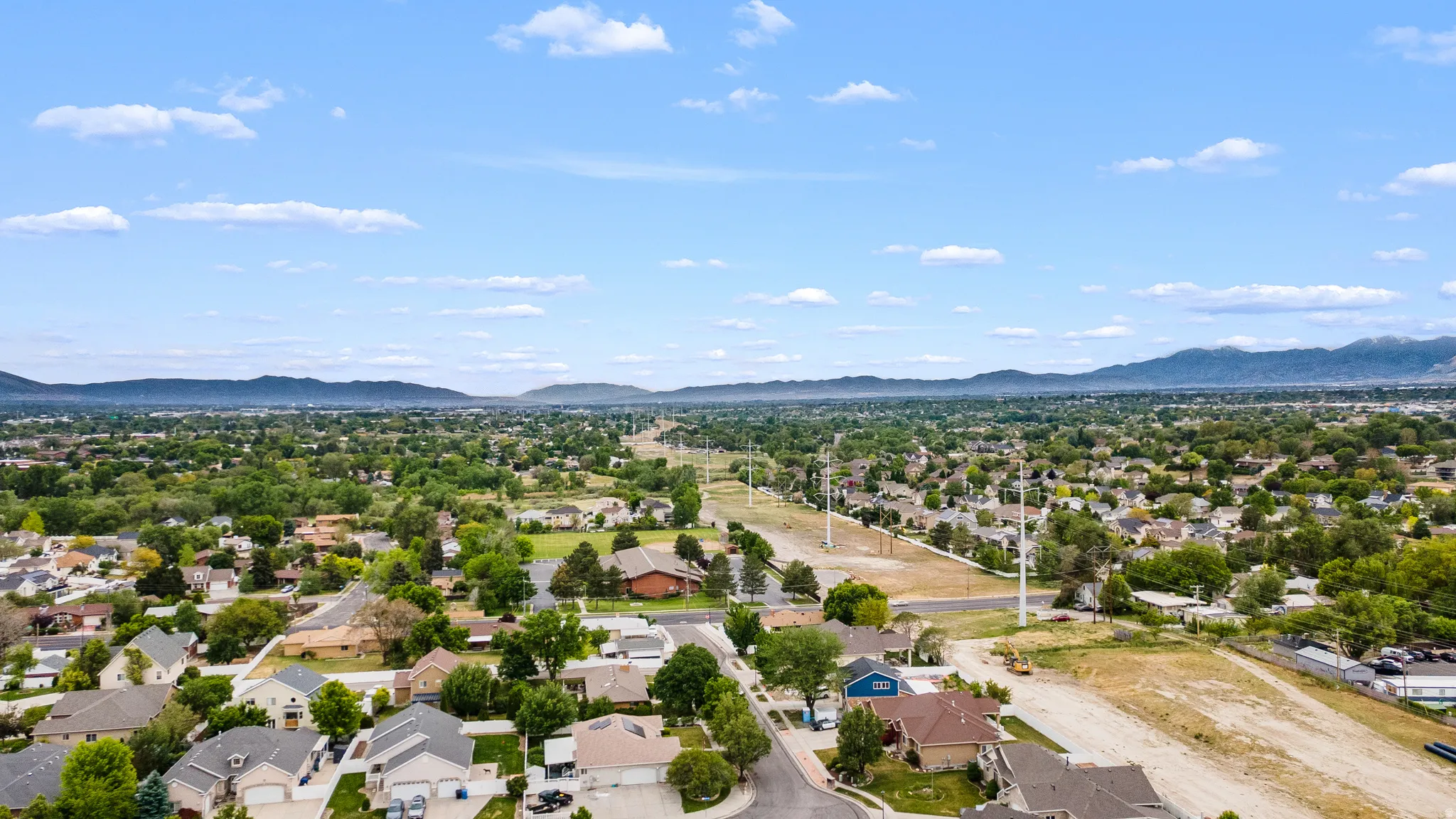 Expansive aerial perspective showcasing a residential area with varied housing styles and mature tree cover