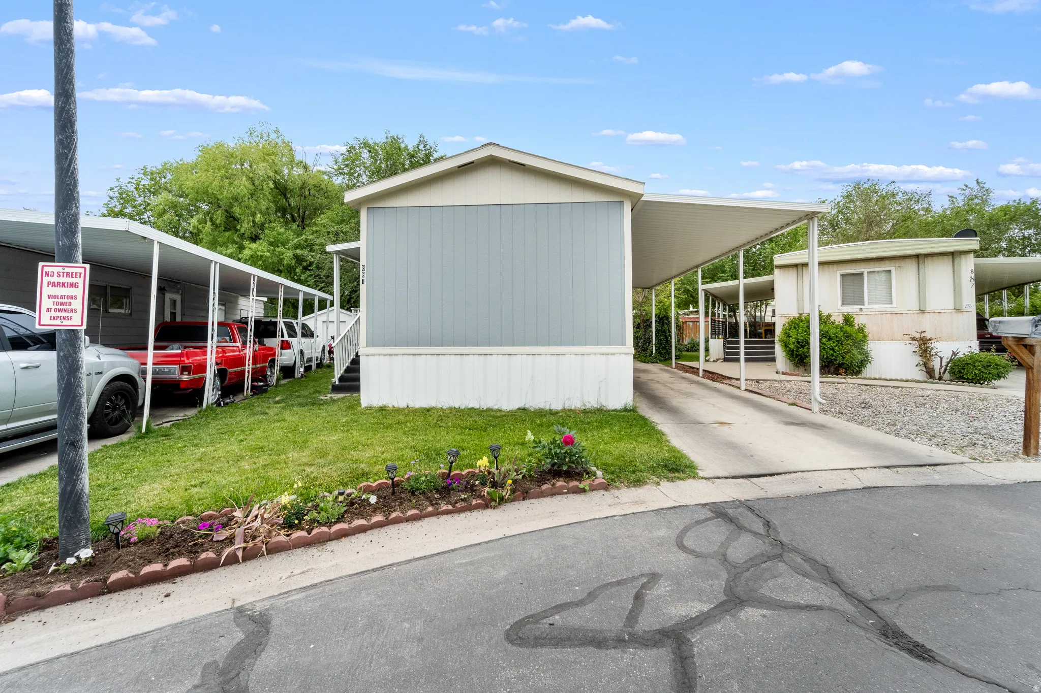 Property exterior featuring light blue siding, white trim, and a white carport