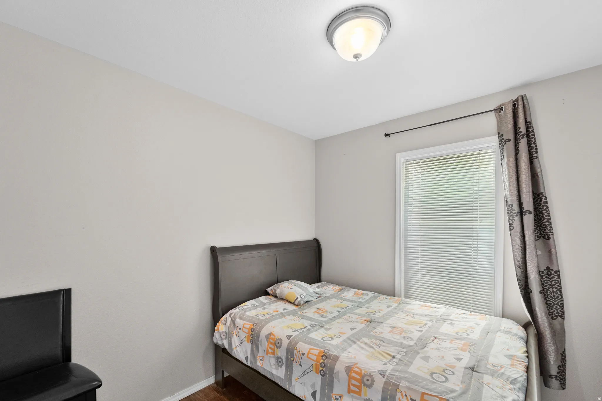 Neutral toned walls with a single window featuring horizontal blinds
