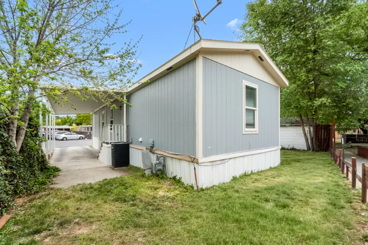 Light blue siding exterior with white trim and a covered carport