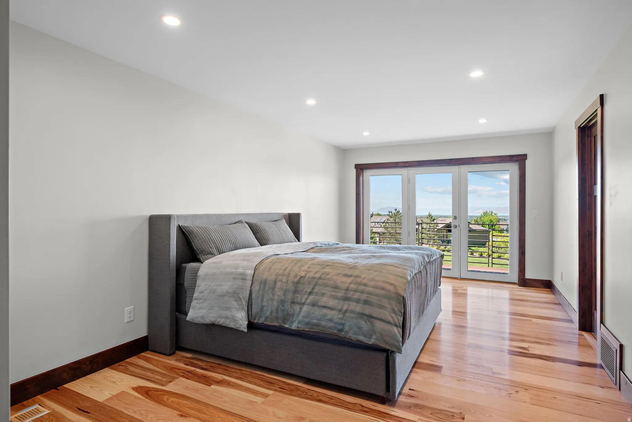 Spacious room featuring light wood-finish flooring and recessed lighting