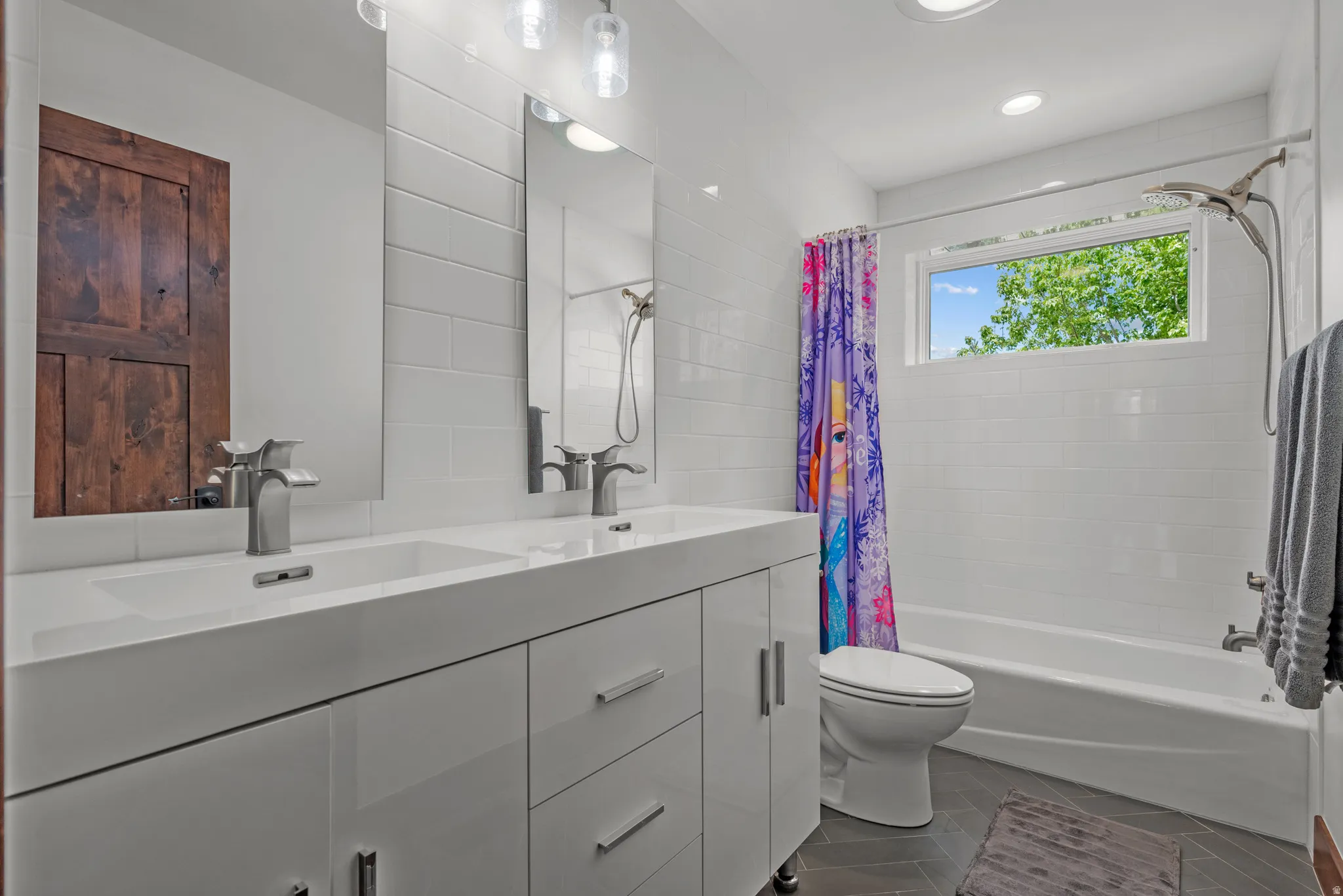 Dual vanity with integrated sinks, brushed nickel faucets, and a white subway tile backsplash