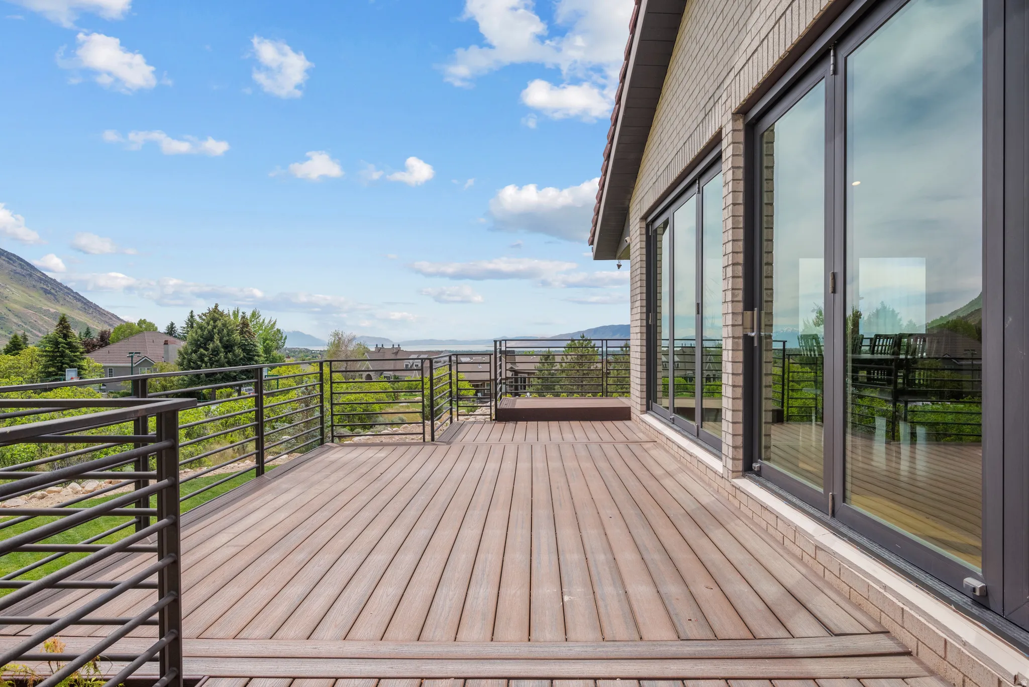 Expansive outdoor deck featuring wood-finish composite decking and a multi-pane sliding glass door system