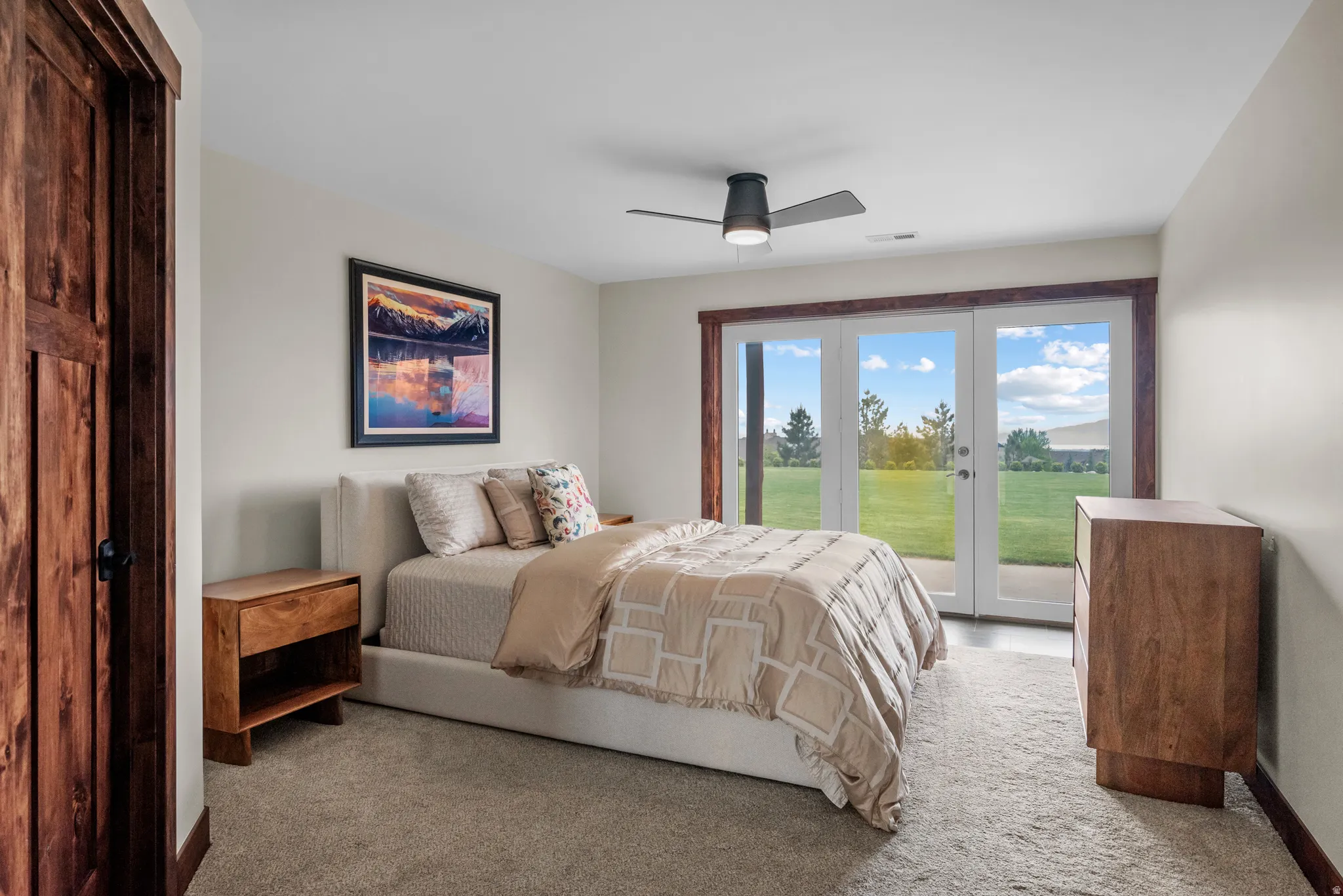 Room featuring white French doors, carpeted flooring, a ceiling fan, and wood trim