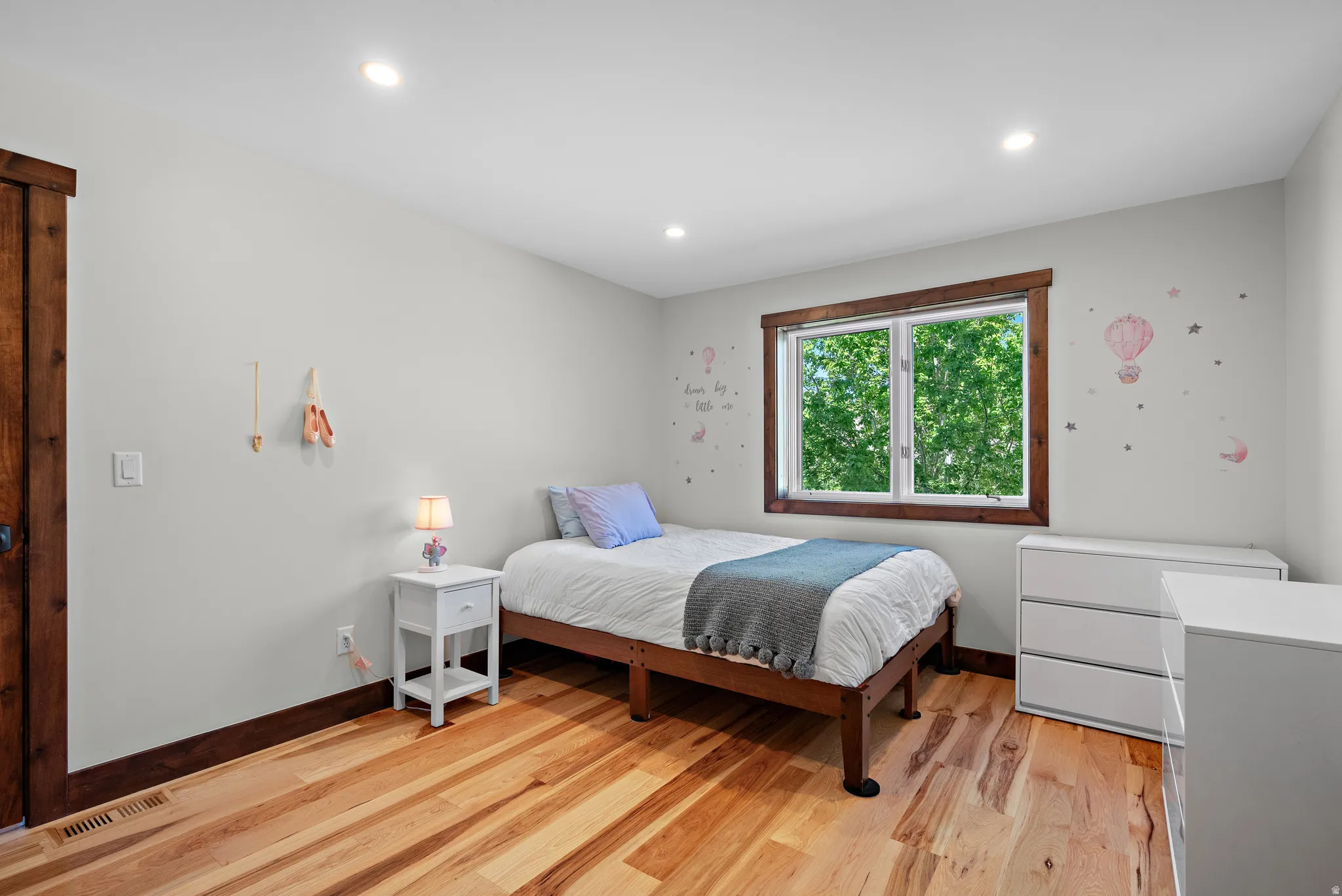 Bedroom featuring light-toned walls, recessed lighting, and wood-finish flooring