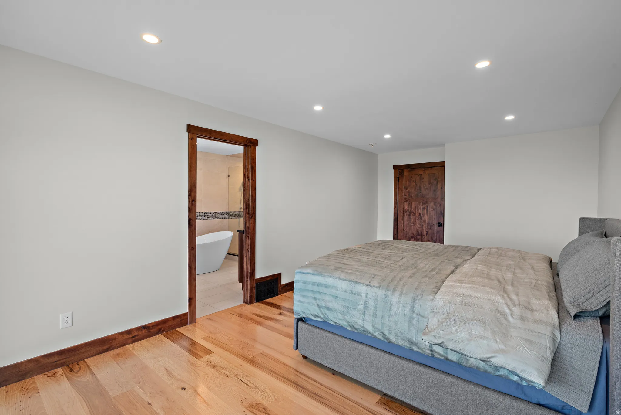 Hardwood flooring complements crisp white walls and recessed lighting