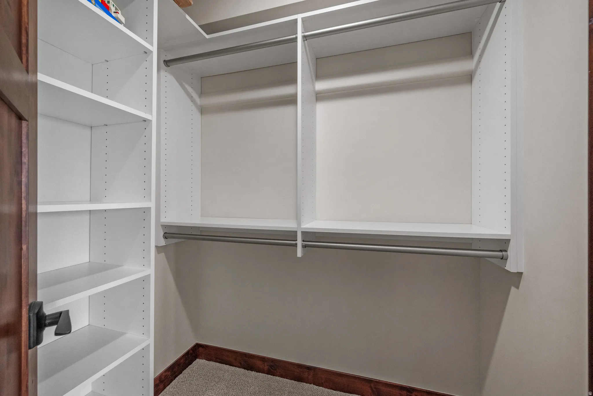 Custom closet system featuring white shelving and hanging rods