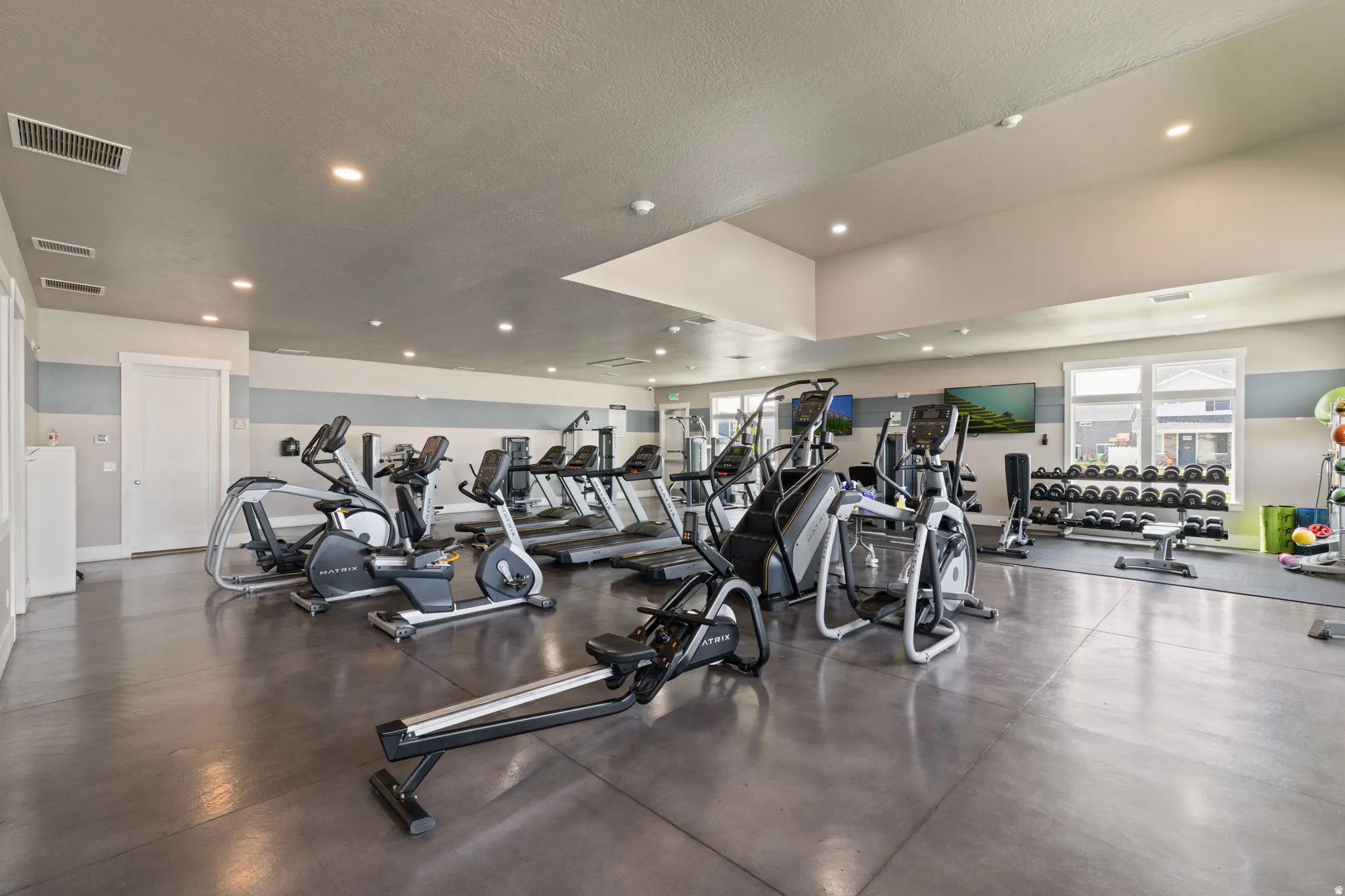 Spacious fitness area featuring durable concrete flooring