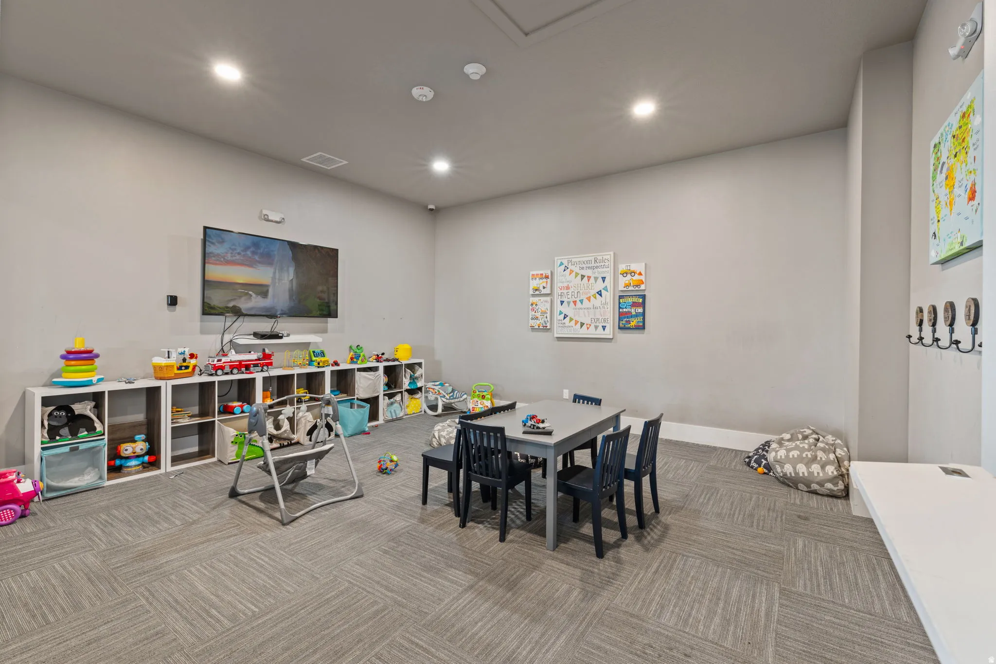 Spacious room featuring gray walls and patterned carpet flooring