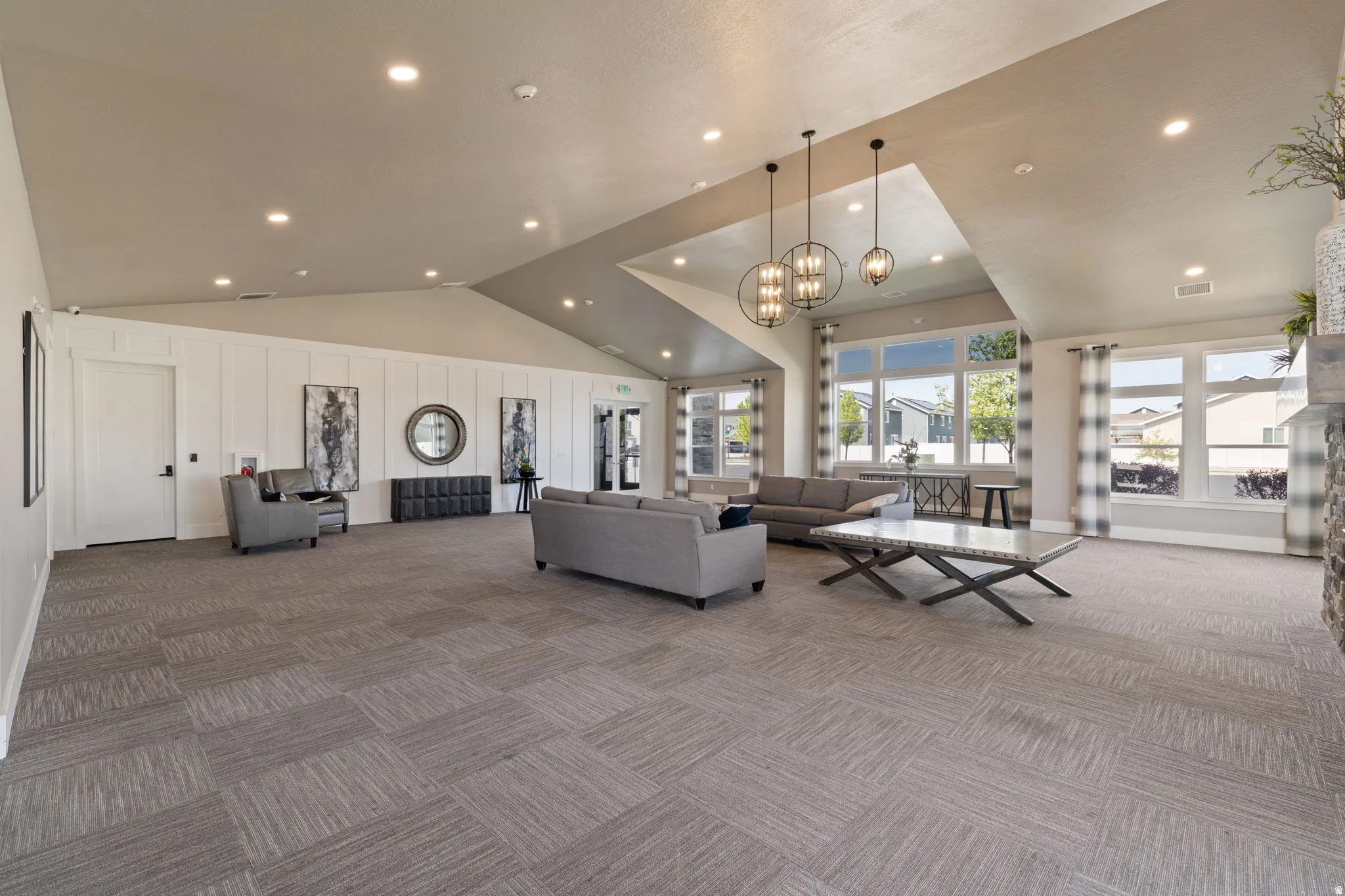 Spacious common area featuring vaulted ceilings, recessed lighting, and large windows providing abundant natural light