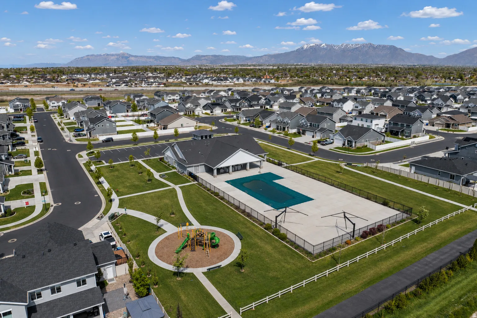 Community amenity area featuring a pool, playground, and clubhouse