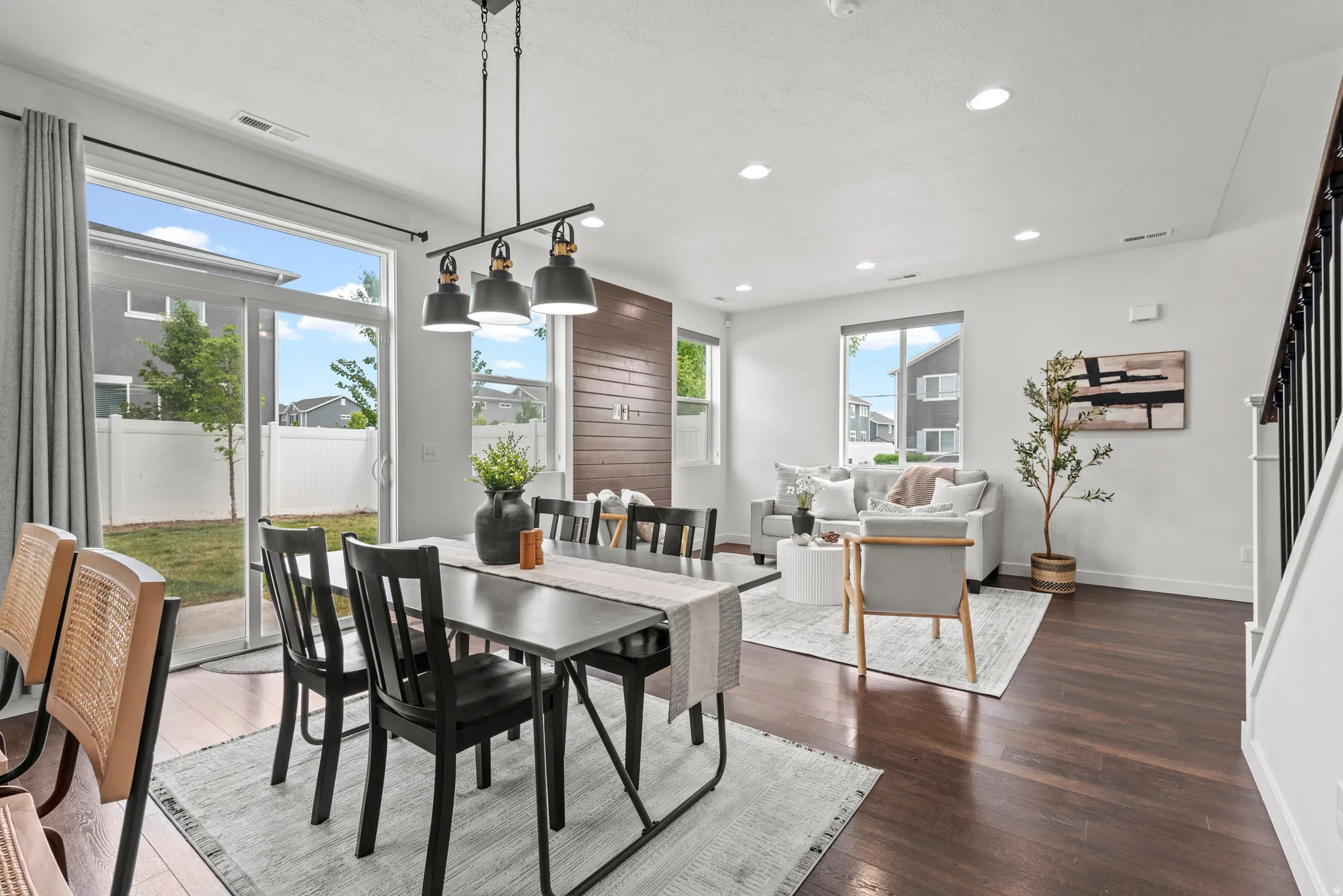 Open-concept living area featuring dark wood-finish flooring, recessed lighting, and a modern chandelier