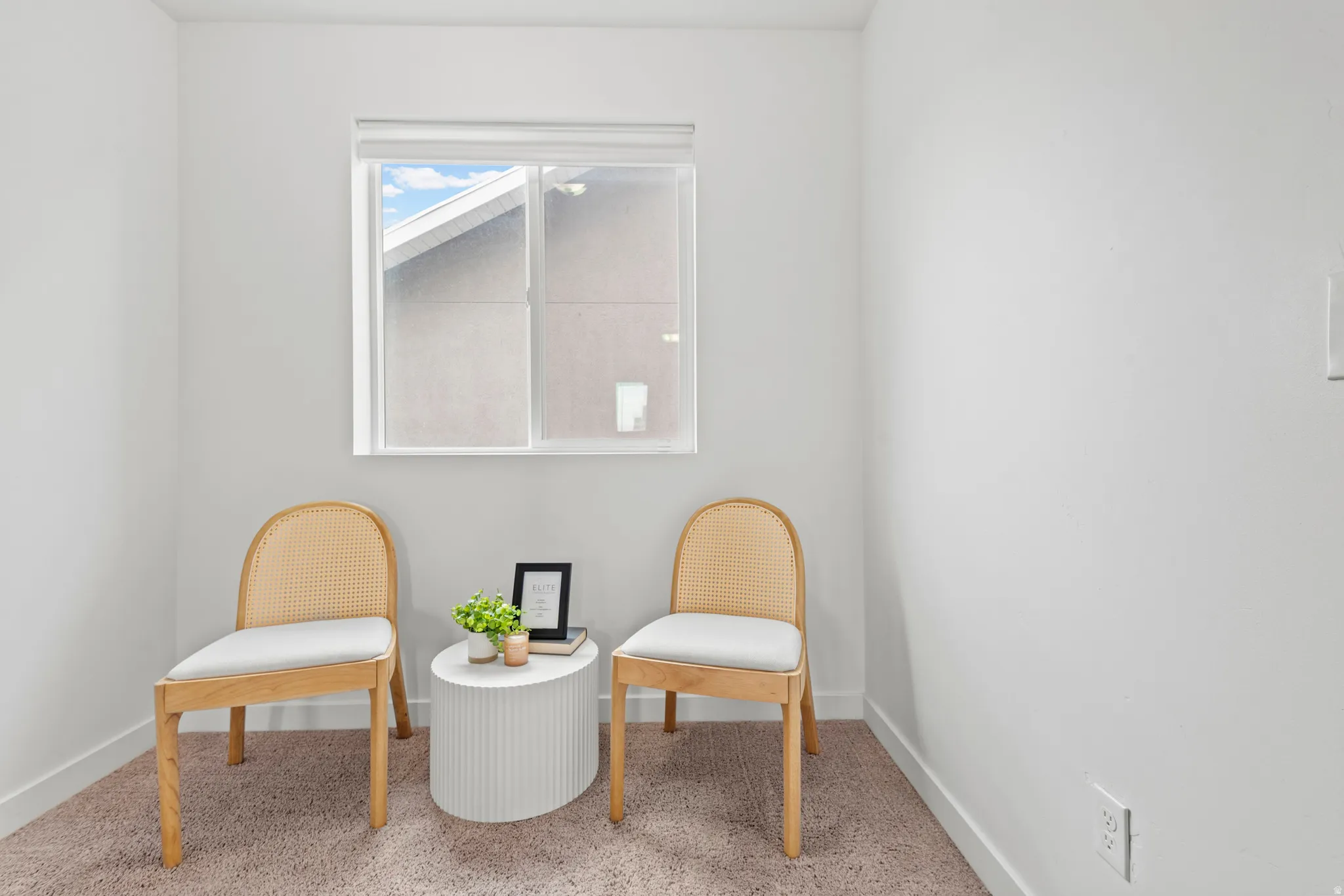 Windowed interior space featuring light-colored carpeting and white walls