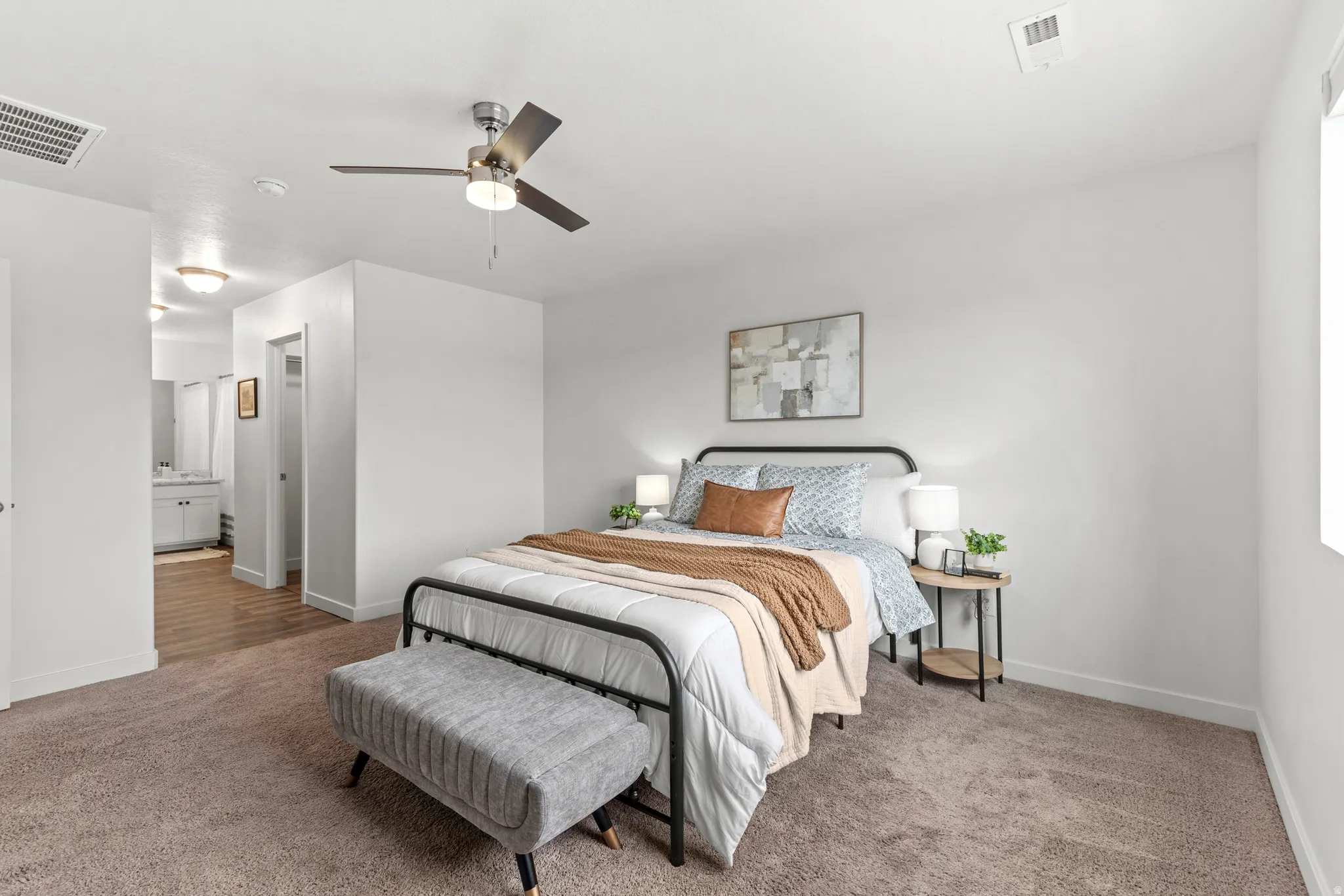 Bedroom featuring a ceiling fan with integrated lighting, window, and carpet flooring