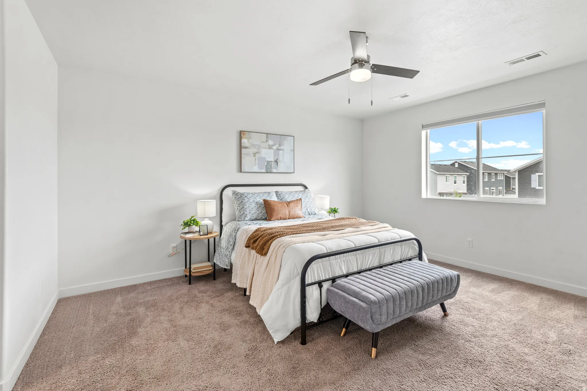 Carpeted bedroom featuring white walls, a single window, and a ceiling fan with integrated lighting