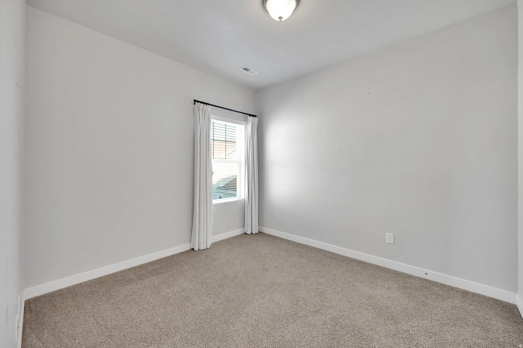 Windowed room featuring neutral wall tones and carpet flooring