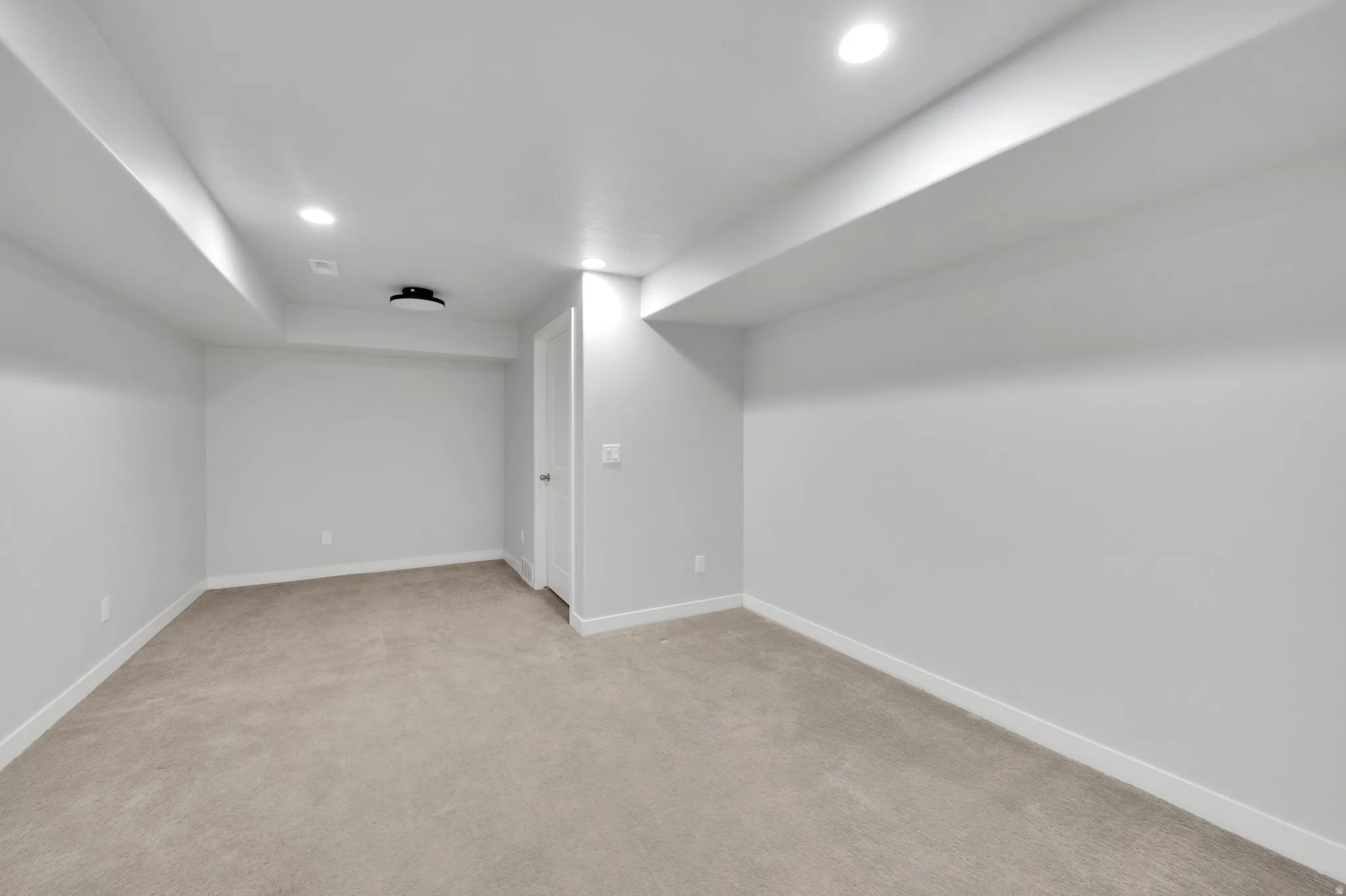 Carpeted room featuring recessed lighting, a ceiling-mounted light fixture, white walls, and white trim