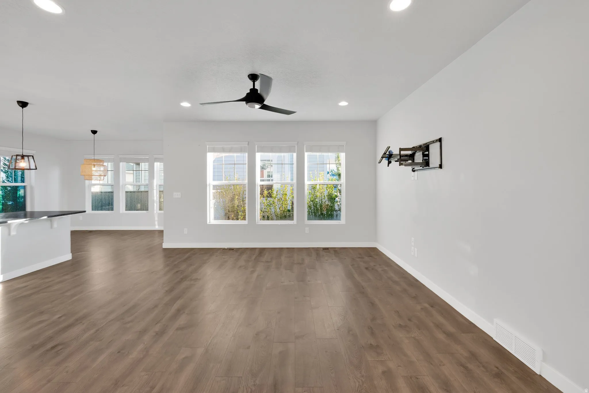 Expansive main living area featuring wood-finish flooring, recessed lighting, and a modern ceiling fan