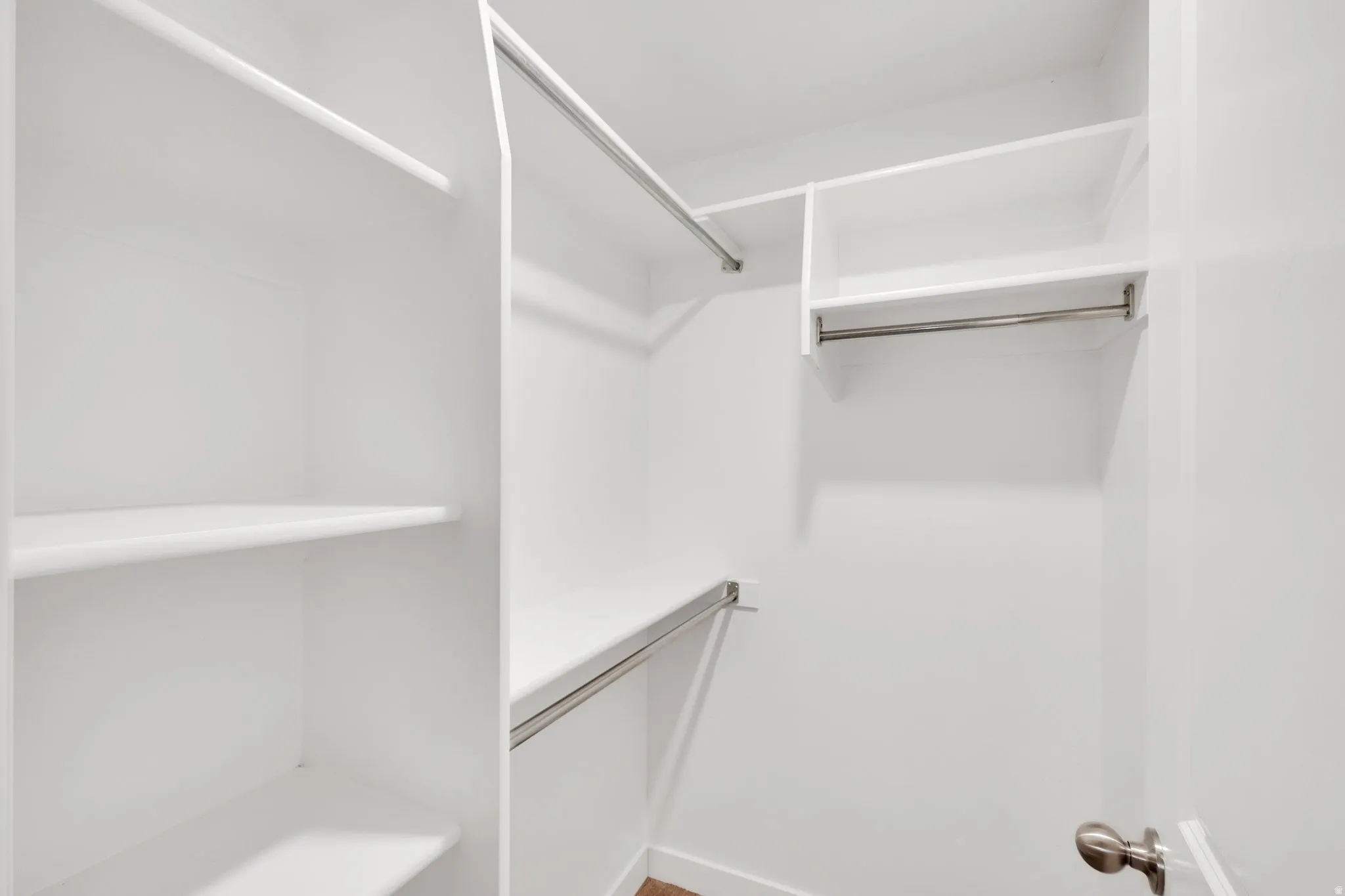White closet system featuring multiple shelving units and hanging rods
