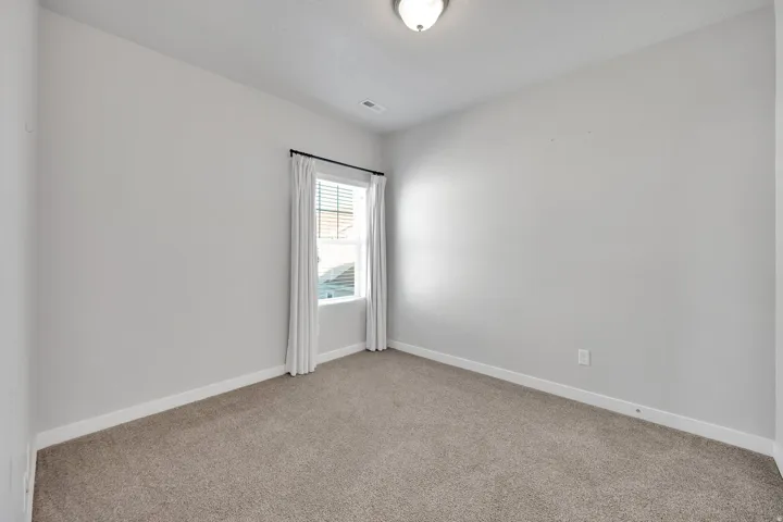 Windowed room featuring neutral wall tones and carpet flooring