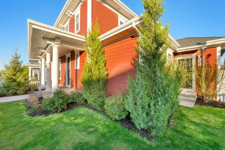 Red siding exterior with white trim details and a covered porch supported by white columns