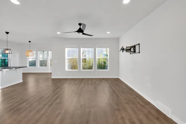 Expansive main living area featuring wood-finish flooring, recessed lighting, and a modern ceiling fan